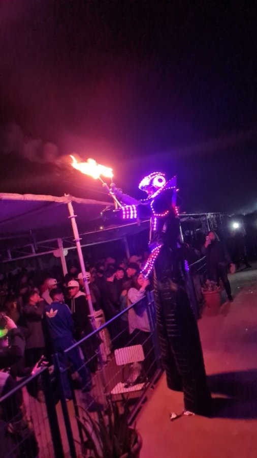 Robot LED con fuego frente a multitud en evento masivo