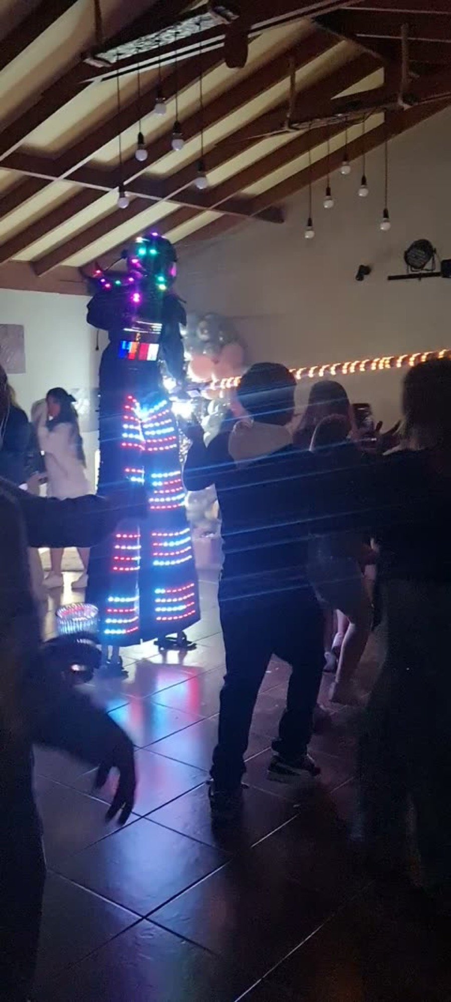 Robot LED bailando con invitados de noche