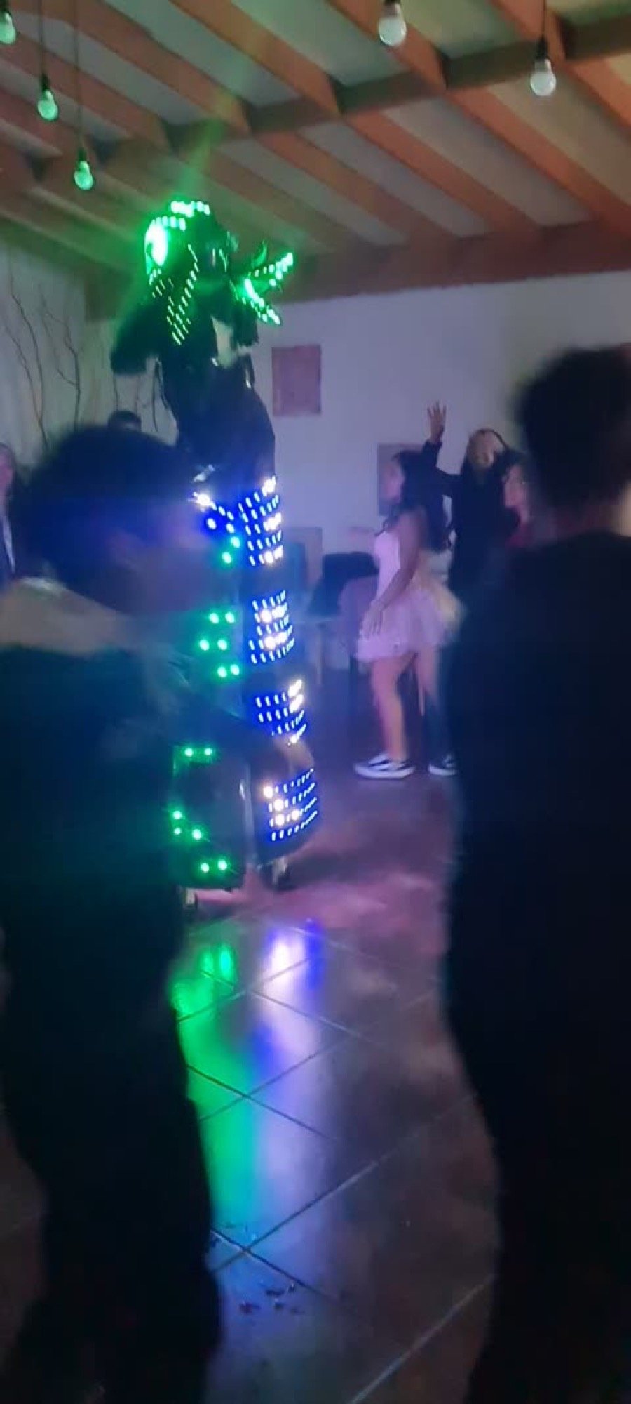 Robot LED verde con niños celebrando